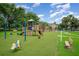 Community playground area featuring a swing set, climbing structure, and artificial turf at 16828 N Gold Star Ct, Clermont, FL 34714