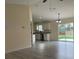 Open-concept living room showcasing modern gray flooring and ample natural light from sliding glass doors to the back yard at 16910 Sw 27 Avenue, Ocala, FL 34473