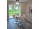 Bright dining area features a sliding glass door, ceiling fan, and modern table with seating for four at 5834 Forest Grove Blvd, Orlando, FL 32808