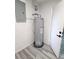 Practical utility area with water heater, electrical panel, and easy-to-maintain wood-look flooring at 5834 Forest Grove Blvd, Orlando, FL 32808