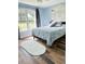 Sunlit bedroom with a large window, modern flooring, and a decorative headboard at 33632 Wesley Rd, Eustis, FL 32736