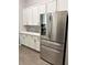 Bright kitchen featuring stainless steel refrigerator and white cabinets with granite countertops at 33632 Wesley Rd, Eustis, FL 32736