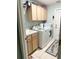 Functional laundry room featuring a utility sink, washer, dryer, overhead cabinets, and access to the backyard at 33632 Wesley Rd, Eustis, FL 32736