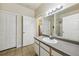 Bathroom with vanity and sink, large mirror, and doors leading to the toilet and the kitchen at 6017 Westgate Dr # 924, Orlando, FL 32835