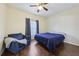 Comfortable bedroom with wood-look floors, ceiling fan, cozy chair, and natural light at 6017 Westgate Dr # 924, Orlando, FL 32835