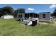 A view of a backyard with a screened-in porch and well-maintained grass at 4861 Myrtle View N Dr, Mulberry, FL 33860