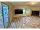 Bright living room with sliding glass door, big-screen TV, and fireplace at 4861 Myrtle View N Dr, Mulberry, FL 33860