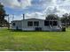 Rear exterior of house with well-maintained lawn and a screened-in porch at 4861 Myrtle View N Dr, Mulberry, FL 33860