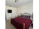 Carpeted bedroom offering a red bedspread and a mounted TV on the wall at 223 Windsor St # 6, Lakeland, FL 33803