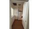 A bright kitchen space featuring white cabinets and appliances with an adjacent pantry for storage at 223 Windsor St # 6, Lakeland, FL 33803