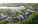 Aerial view displaying a neighborhood with a scenic pond surrounded by well-maintained houses and lush greenery at 10084 Moss Rose Way, Orlando, FL 32832