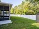 Spacious back yard with a white fence, lush lawn, and a screened-in porch perfect for outdoor relaxation at 10084 Moss Rose Way, Orlando, FL 32832