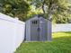 Backyard shed with gray wood paneled walls and black hardware at 10084 Moss Rose Way, Orlando, FL 32832
