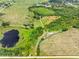 Aerial view of property featuring pond, large acreage, and wooded areas at 2440 S Wallace Rd, Bartow, FL 33830