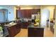 Well-equipped kitchen featuring dark wood cabinets, granite countertops, and a kitchen island at 6832 Thornhill Cir, Windermere, FL 34786