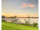 Stunning lake view at sunset featuring a gazebo-covered pier, perfect for relaxation and enjoying nature's beauty at 6832 Thornhill Cir, Windermere, FL 34786
