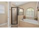 Bright bathroom featuring a soaking tub with tile surround and a separate glass shower at 852 Desert Mountain Ct, Reunion, FL 34747