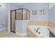 The bathroom features a glass shower and a relaxing tub, perfect for unwinding after a long day at 852 Desert Mountain Ct, Reunion, FL 34747