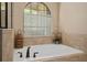 Bathroom showcasing a soaking tub with tile surround and a large window at 852 Desert Mountain Ct, Reunion, FL 34747