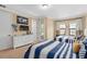 Bedroom featuring matching twin beds, dresser with TV, and access to a balcony at 852 Desert Mountain Ct, Reunion, FL 34747