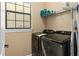 Practical laundry room featuring modern, side-by-side washer and dryer units, and convenient shelving for storage at 852 Desert Mountain Ct, Reunion, FL 34747