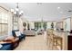 Open-concept living room with neutral furniture, tile floors, and bar seating at 852 Desert Mountain Ct, Reunion, FL 34747