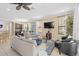 Open-concept living room with comfortable sofas, a ceiling fan, and plenty of natural light from the surrounding windows at 852 Desert Mountain Ct, Reunion, FL 34747