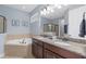 Elegant main bathroom featuring a double vanity, soaking tub, walk-in shower, and modern fixtures at 852 Desert Mountain Ct, Reunion, FL 34747