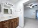 Bathroom with wood vanity, granite countertops, and a large mirror over the sink at 1938 E Fern Rd, Lakeland, FL 33801
