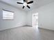 Bright bedroom features light gray floors, ceiling fan, and a doorway that leads to other rooms at 1938 E Fern Rd, Lakeland, FL 33801