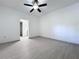 Bright bedroom features light gray floors, ceiling fan, and a doorway that leads to other rooms at 1938 E Fern Rd, Lakeland, FL 33801