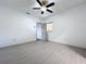 Bright bedroom features light gray floors, ceiling fan, and a doorway that leads to other rooms at 1938 E Fern Rd, Lakeland, FL 33801