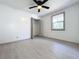 Bedroom features light gray floors, ceiling fan, closet, and a window to allow natural light in at 1938 E Fern Rd, Lakeland, FL 33801