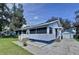 Charming exterior of a light blue home with a screened-in porch and detached garage at 1938 E Fern Rd, Lakeland, FL 33801