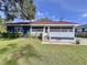 Charming single-story home featuring a well-maintained lawn and screened-in porch at 1938 E Fern Rd, Lakeland, FL 33801