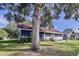Charming single-story home featuring a well-maintained lawn and screened-in porch at 1938 E Fern Rd, Lakeland, FL 33801