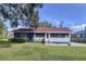 Charming single-story home with a well-maintained lawn and partial blue and white exterior at 1938 E Fern Rd, Lakeland, FL 33801