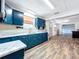 Updated kitchen with bold blue cabinets, marble countertops, and modern fixtures with wood-look floors at 1938 E Fern Rd, Lakeland, FL 33801