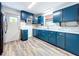 Remodeled kitchen featuring blue cabinets, marble countertops, and stainless steel appliances for modern convenience at 1938 E Fern Rd, Lakeland, FL 33801