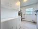 Bright laundry room with white cabinets, ample counter space, and a large window for natural light at 1938 E Fern Rd, Lakeland, FL 33801