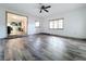Spacious living room with hardwood floors, bright windows, and a view into the kitchen at 1938 E Fern Rd, Lakeland, FL 33801