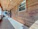 Inviting covered patio with wood paneling, tiled floor, and a cozy swing at 1938 E Fern Rd, Lakeland, FL 33801