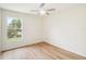 This airy bedroom boasts wood floors and natural light from the window, enhancing its welcoming feel at 818 Cherry Laurel St, Minneola, FL 34715