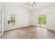 A bright, spacious main bedroom with wood floors, a ceiling fan, and sliding glass doors to the backyard at 818 Cherry Laurel St, Minneola, FL 34715