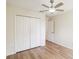 Bright bedroom features a ceiling fan, wood floor and a closet with white bi-fold doors at 818 Cherry Laurel St, Minneola, FL 34715