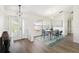 Dining room featuring hardwood floors, modern lighting fixture, large windows, and seating for six at 818 Cherry Laurel St, Minneola, FL 34715
