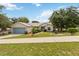 Charming single-story home featuring a well-manicured lawn, mature trees, and an attached two-car garage at 818 Cherry Laurel St, Minneola, FL 34715