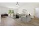 Bright living room featuring vaulted ceiling, neutral decor, modern lighting, and sleek hardwood flooring at 818 Cherry Laurel St, Minneola, FL 34715