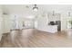 Open floor plan with wood flooring seamlessly connecting the living, dining, and kitchen areas at 818 Cherry Laurel St, Minneola, FL 34715