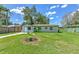 View of the home's front yard with a garden and healthy green grass at 475 W Ethelene St, Bartow, FL 33830
